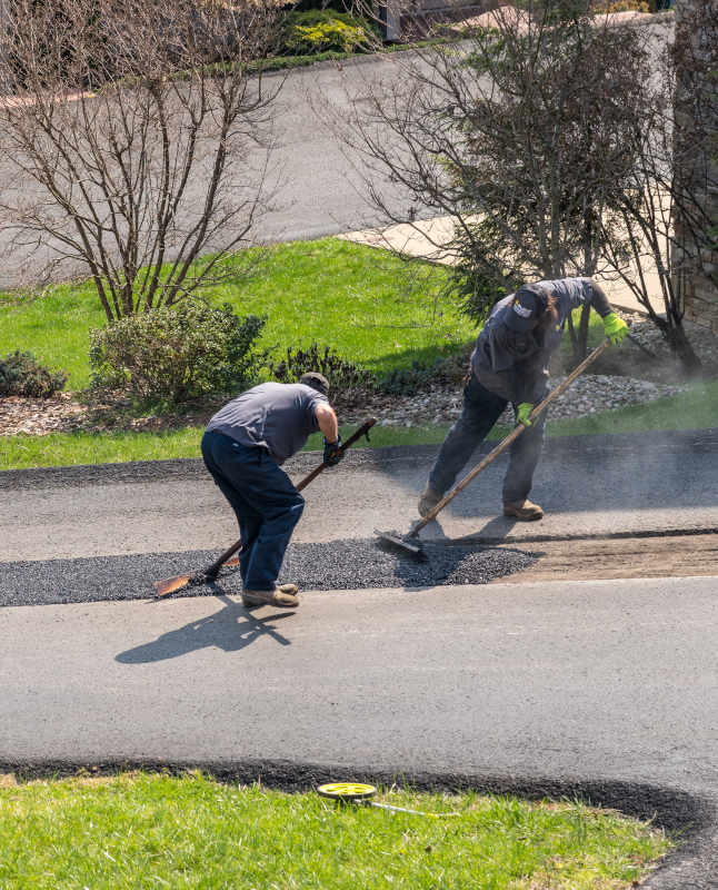 Workers applying repairing asphalt street
