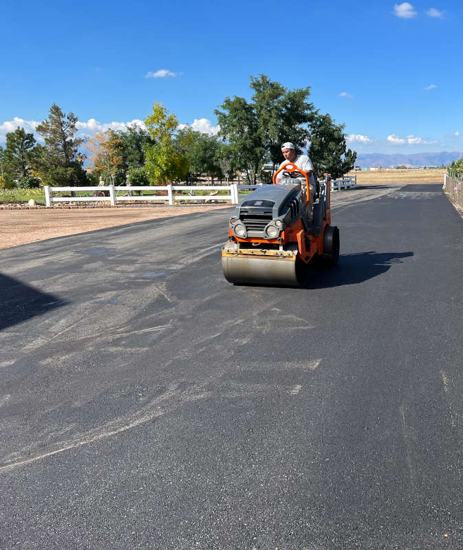 roller compacting new asphalt on a parking lot
